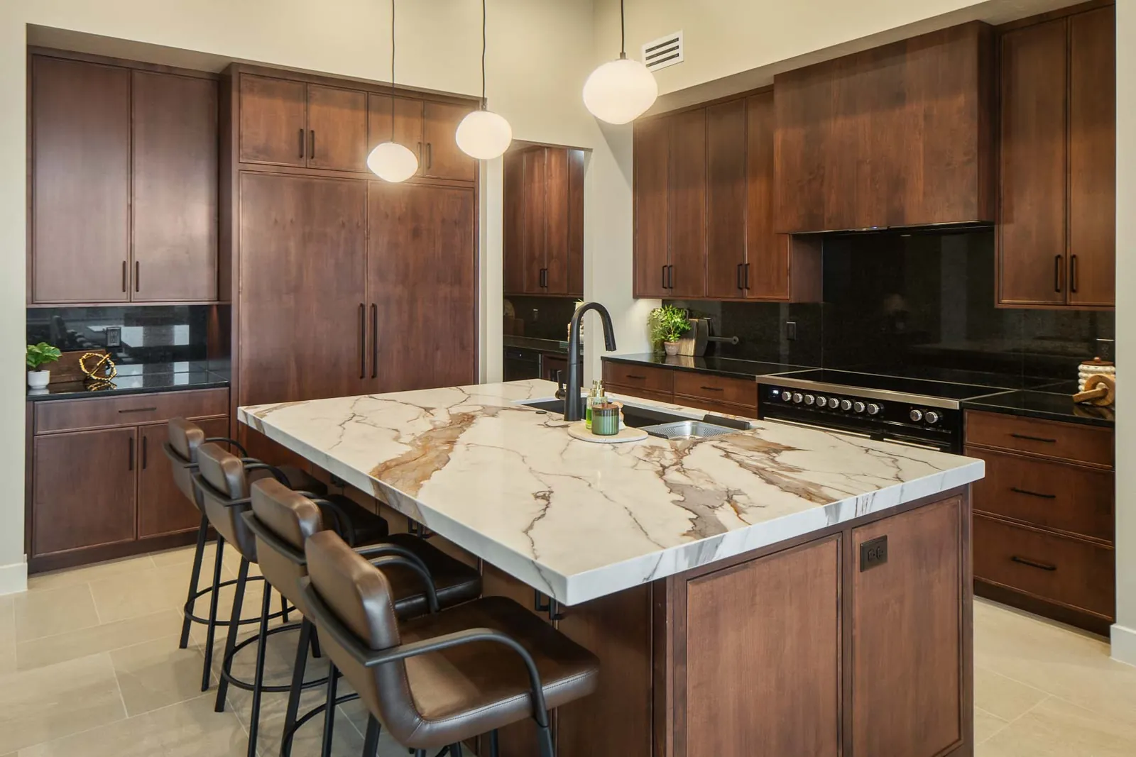 Kitchen with dark wood cabinets and a marble island