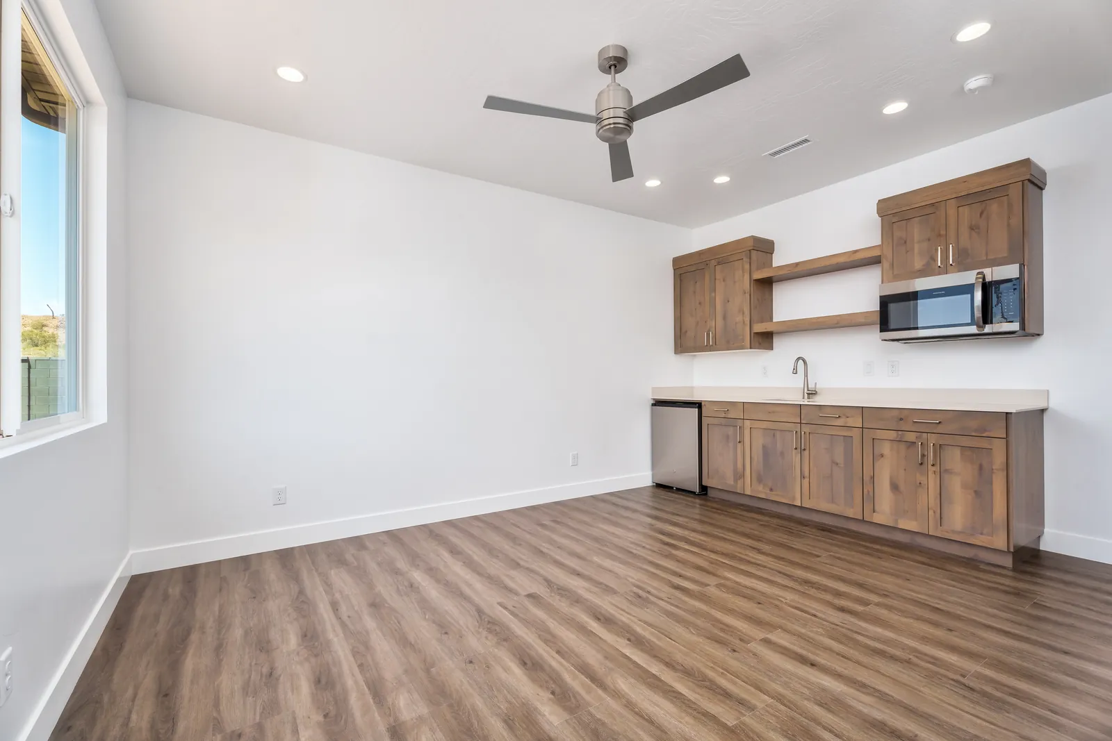 Casita kitchenette with wood cabinets and a small refrigerator