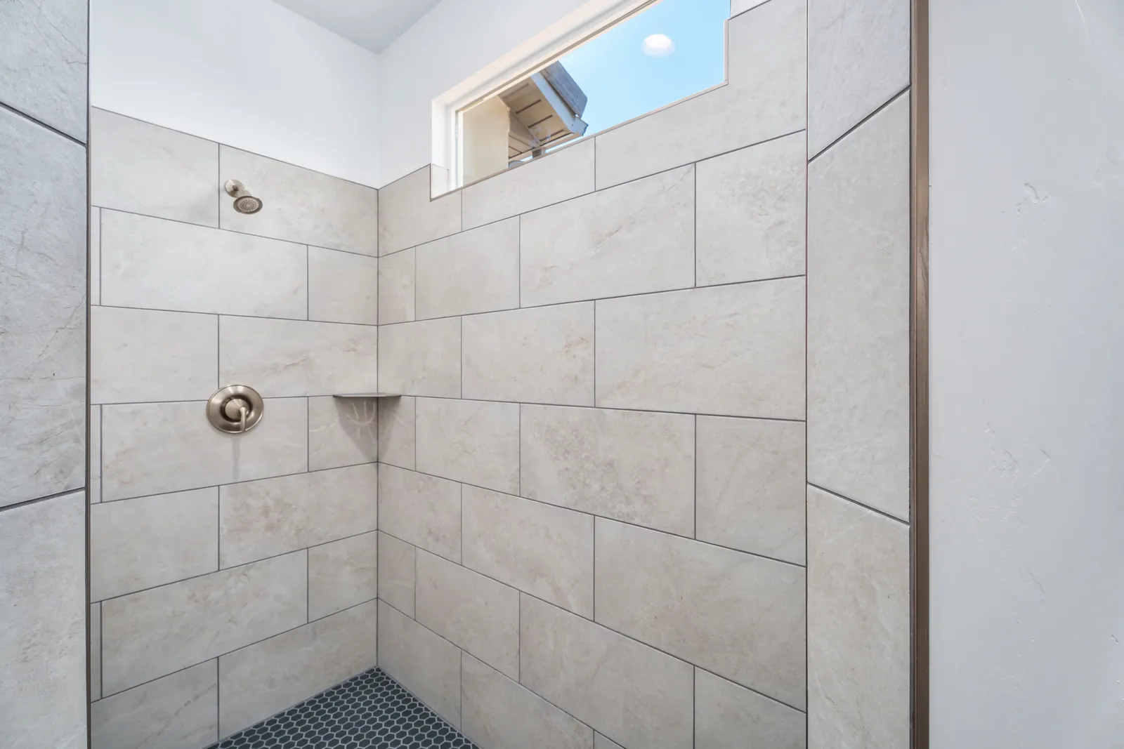 Tiled walk-in shower with a niche