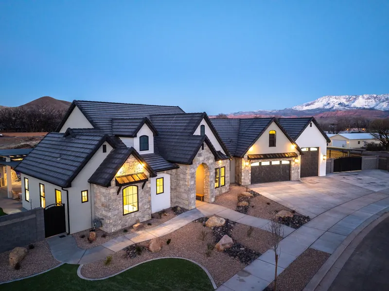 Home with gabled roofs at dusk, with snow on the mountains behind