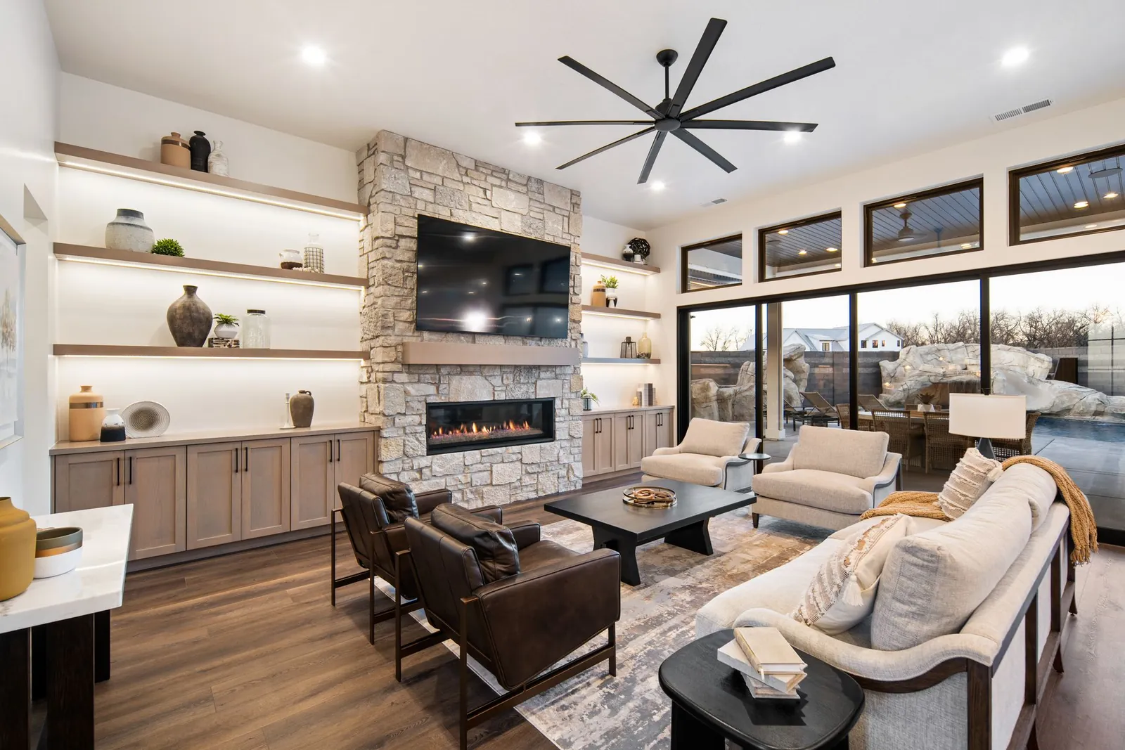 Great room with a stone fireplace and built-in shelves