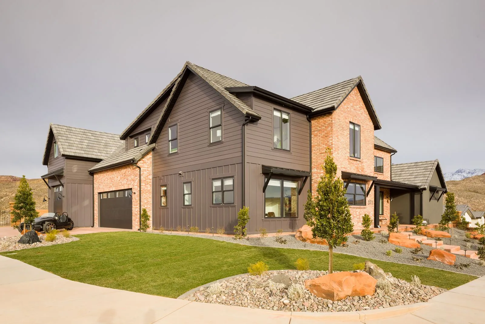 Two-story farmhouse-style home with a lawn and landscaping