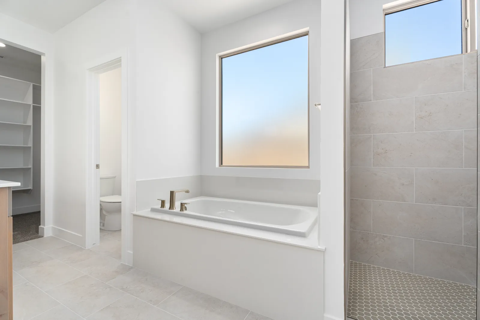 Primary bathroom with a soaking tub and a tiled shower