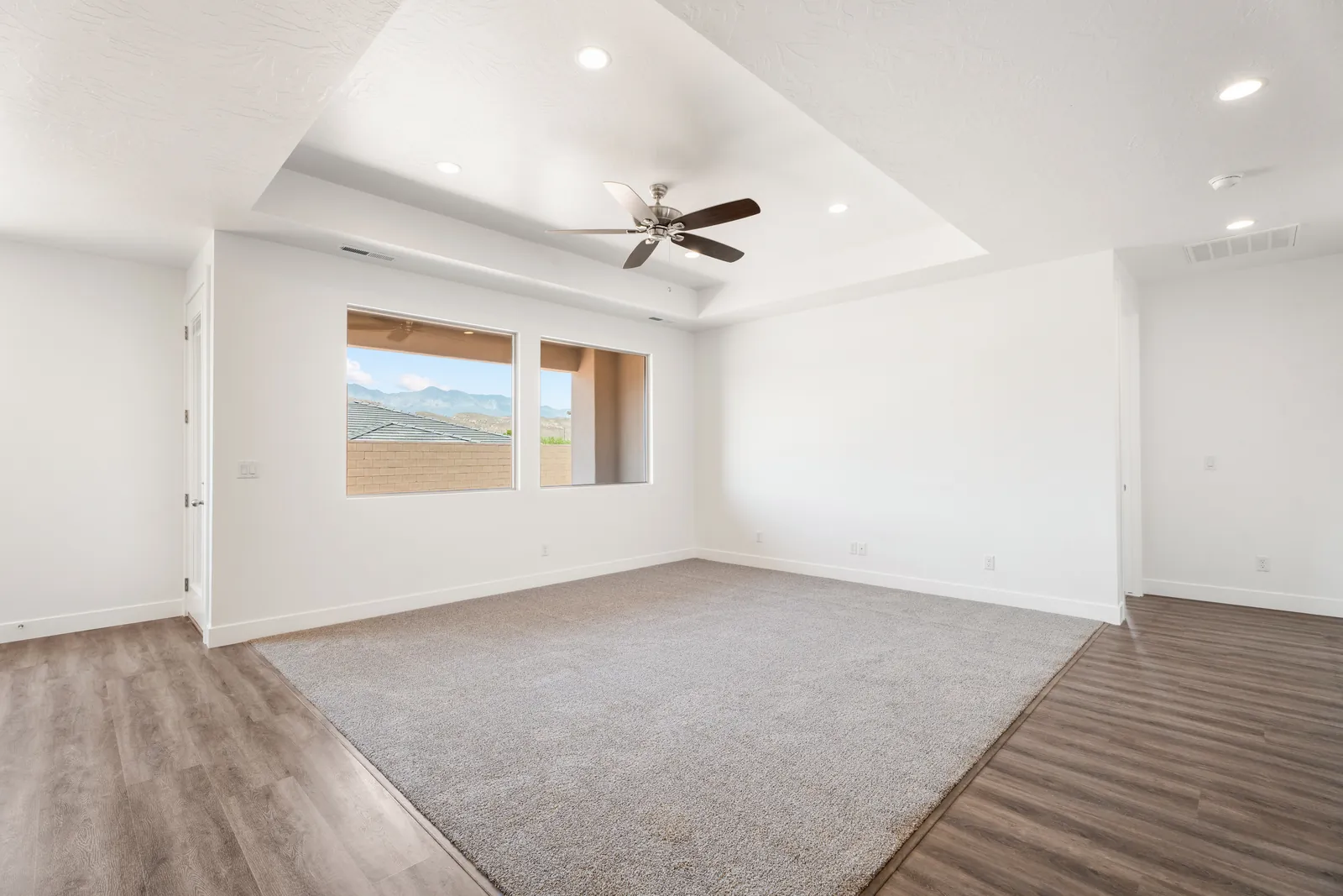 Great room with a tray ceiling and two large windows