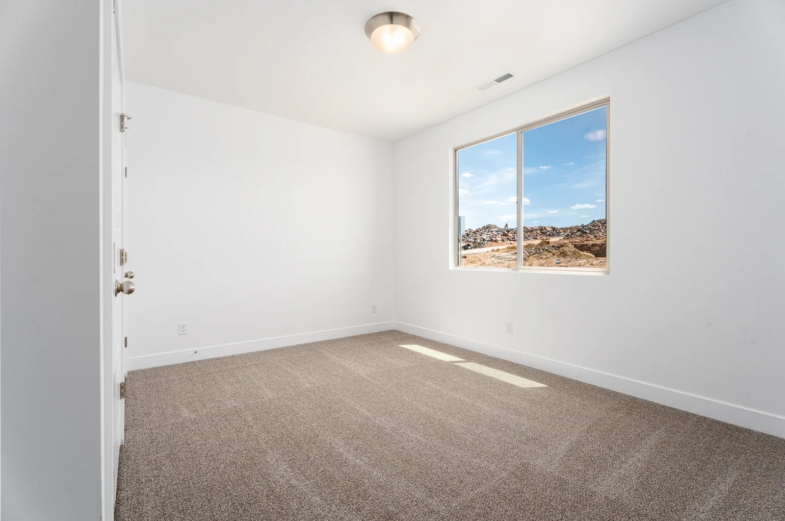 Bedroom window framing red rock hills