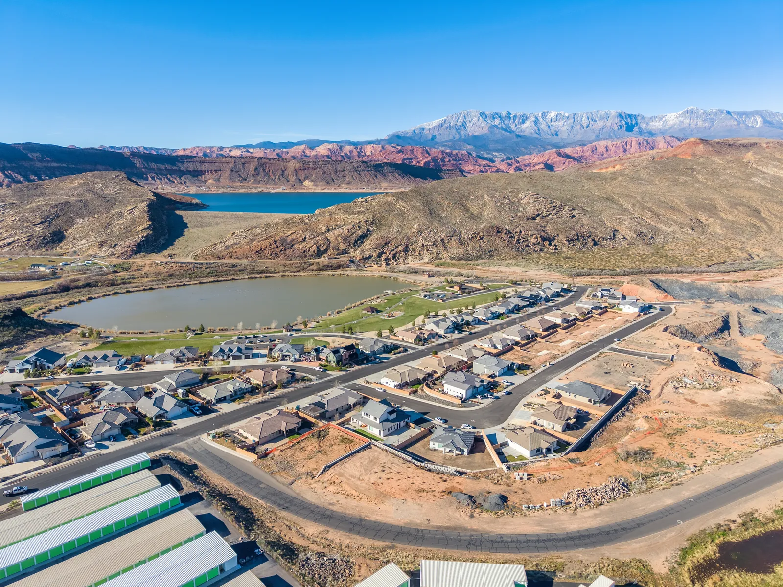 Aerial view looking past Grandpa's Pond toward a larger reservoir and snow-capped peaks