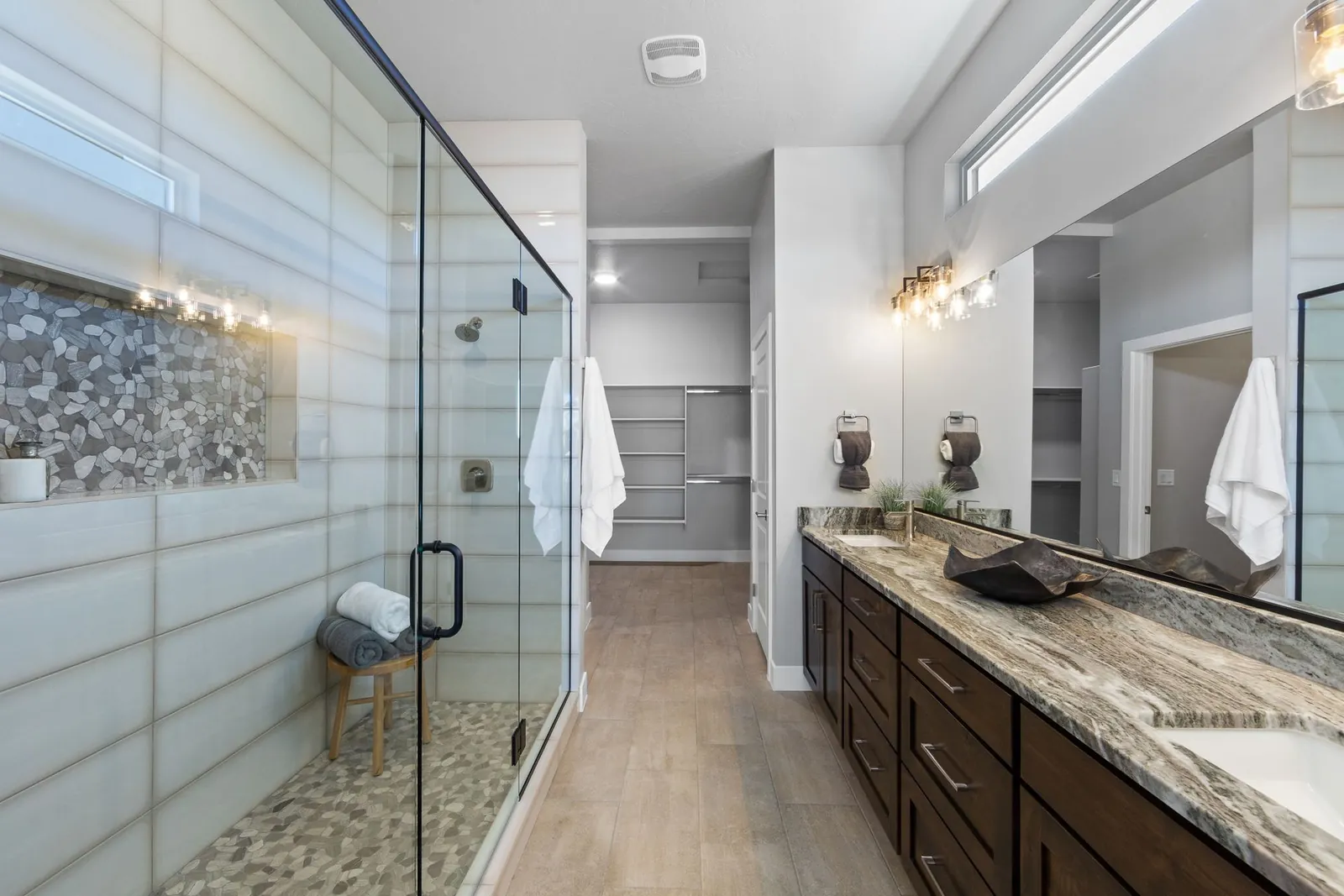 Walk-in glass shower with a stone accent