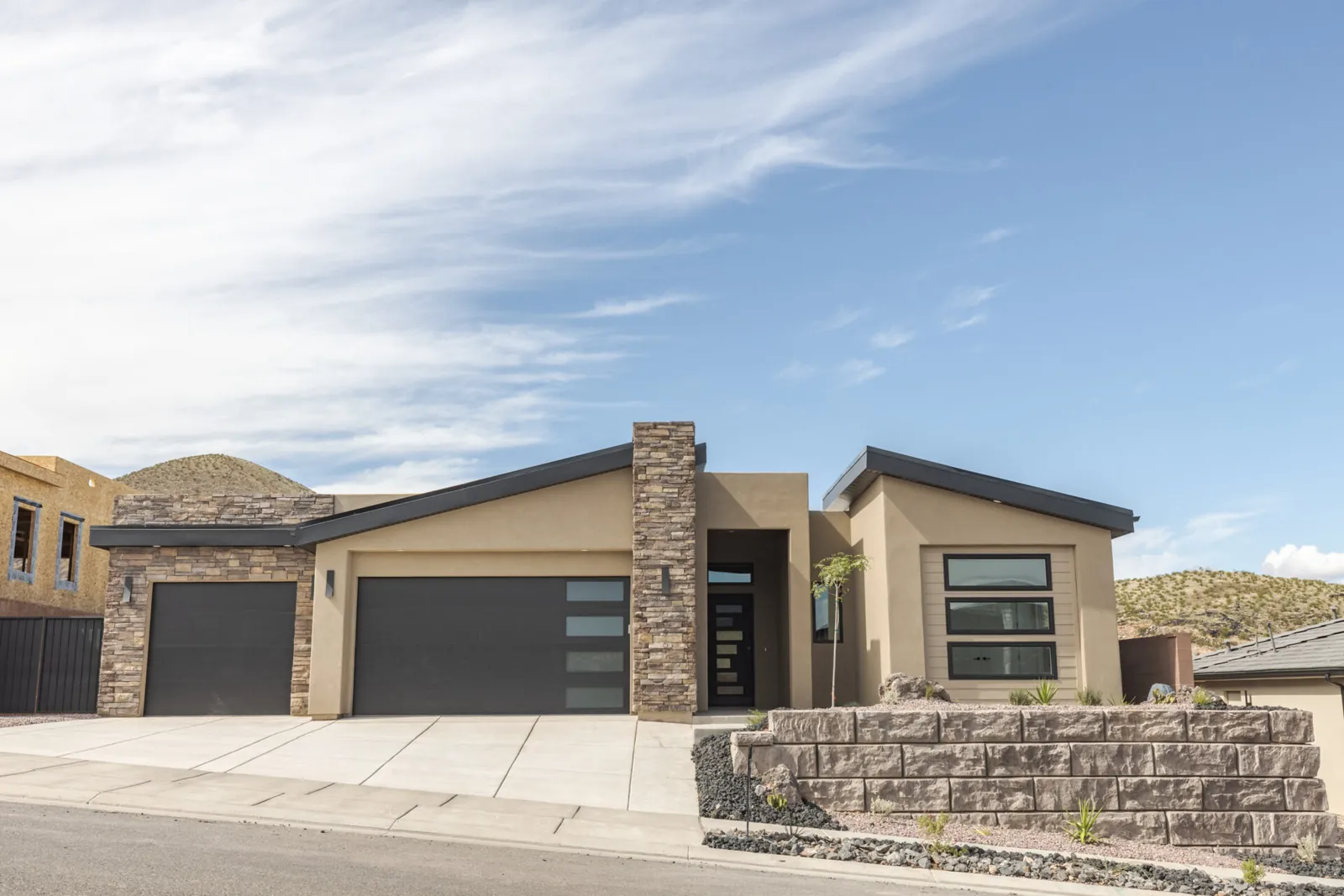 Modern single-story home with a stone column and two garage doors
