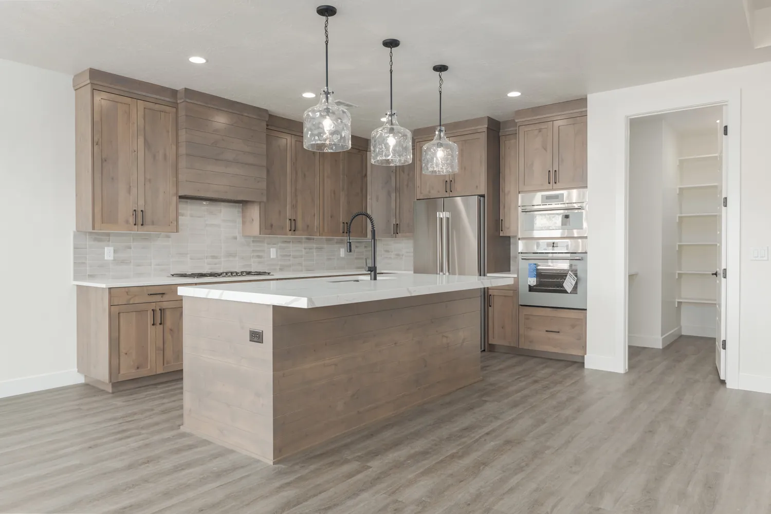 Kitchen with wood cabinets and glass pendant lights