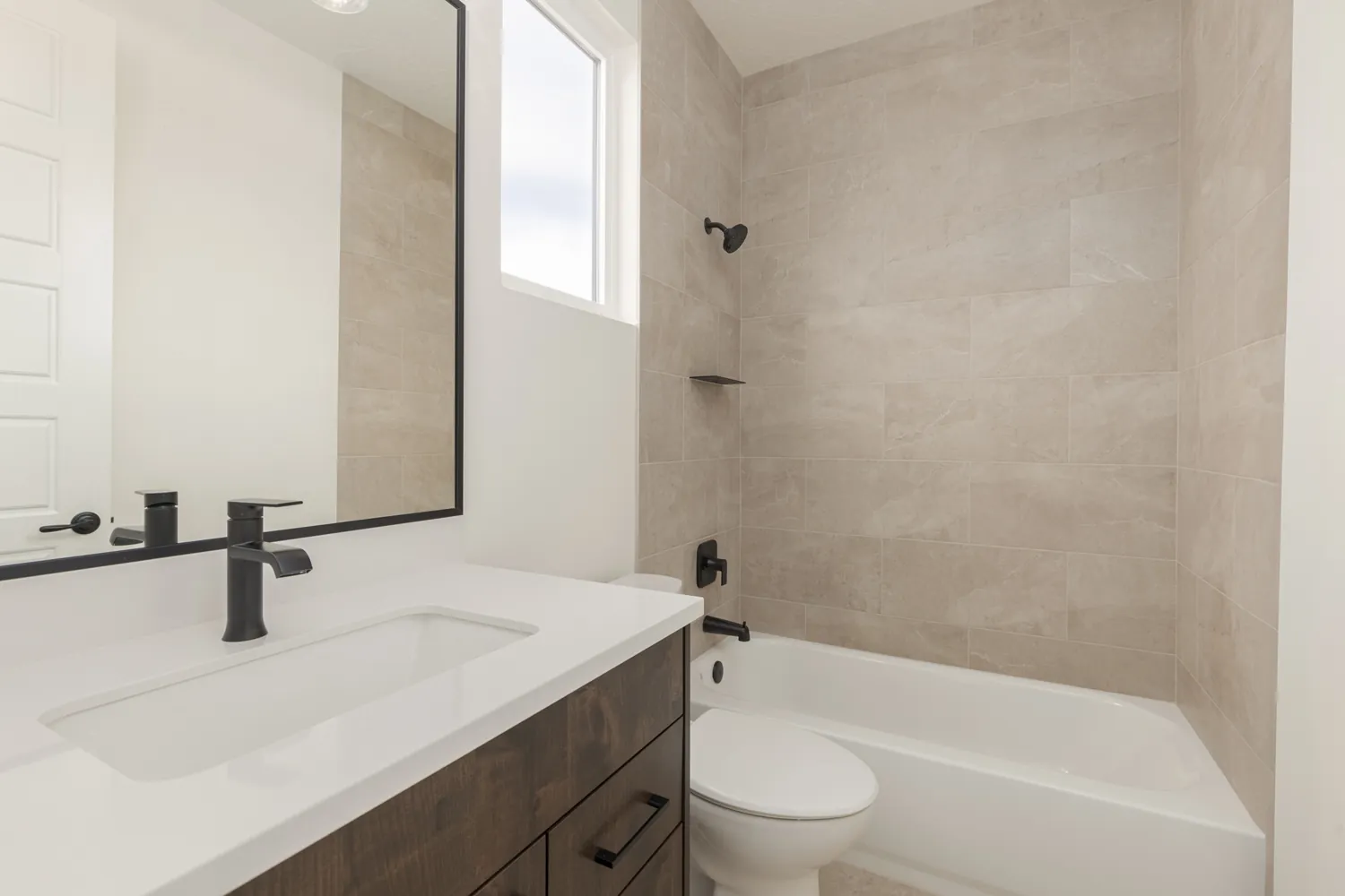 Bathroom with a black mirror and a tiled tub