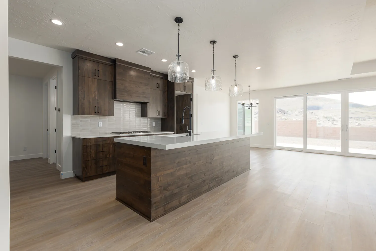 Kitchen island with dark wood cabinets and pendant lights