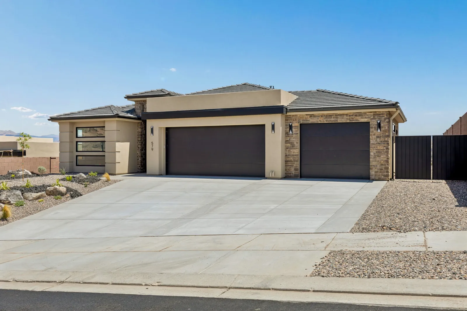 Single-story home with two garage doors and a stone front