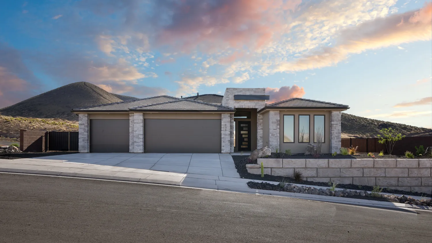 Single-story home with two garage doors under a sunset sky