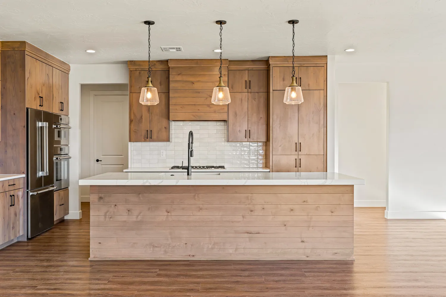 Kitchen with light wood cabinets and pendant lights