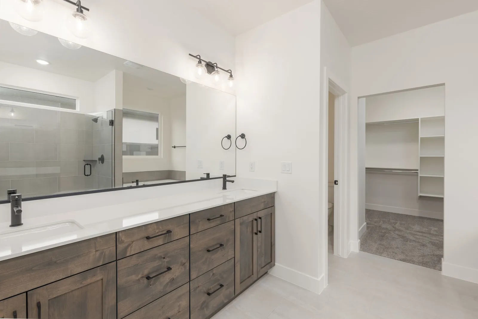 Double vanity with a walk-in closet beyond