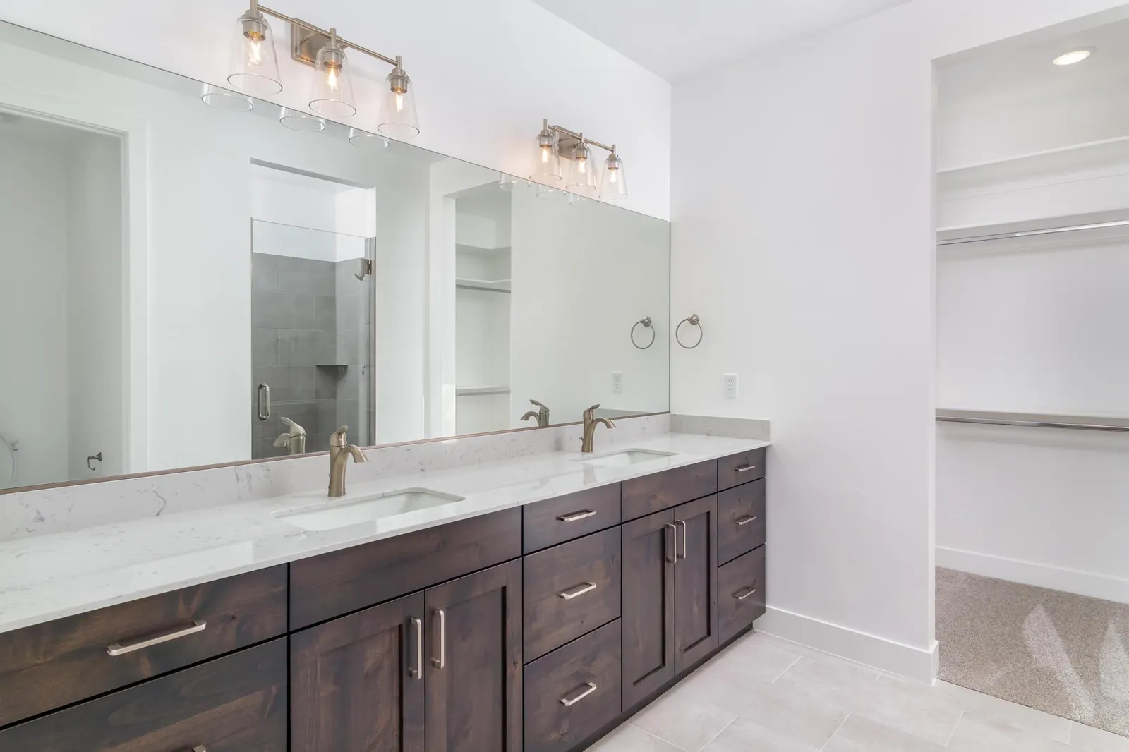 Double vanity with a walk-in closet beyond
