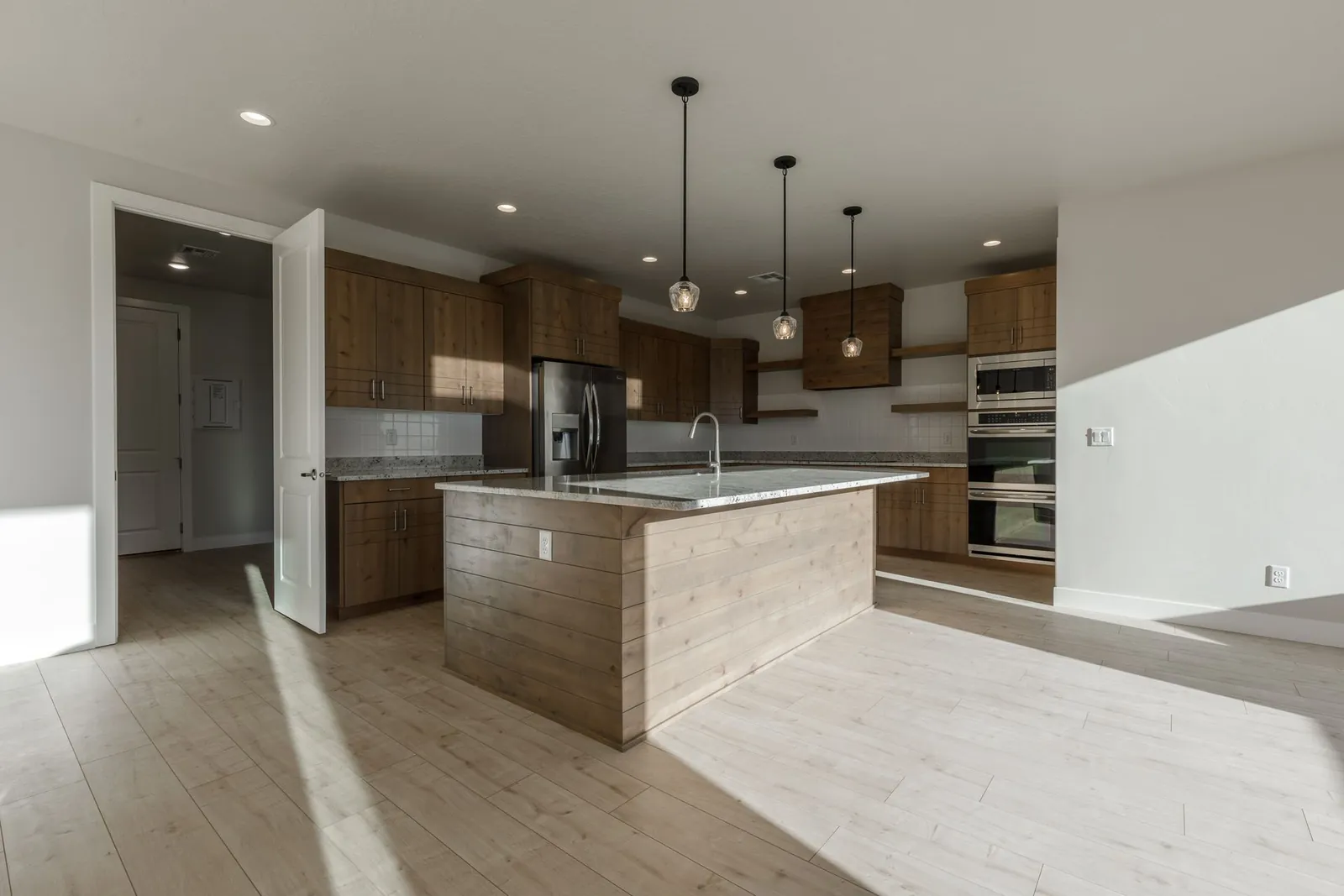 Kitchen island with wood cabinets and pendant lights