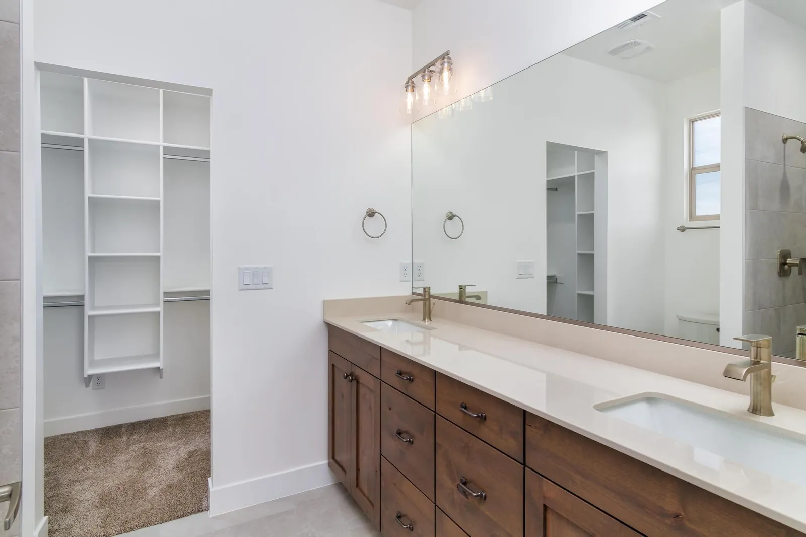 Double vanity with a walk-in closet beyond