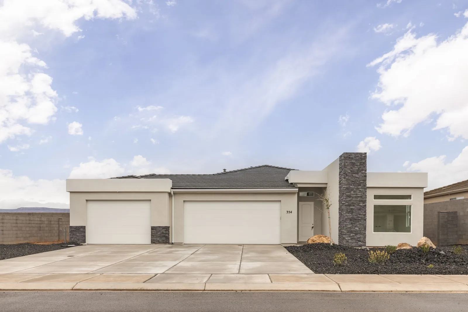 Single-story home with a stone column and two garage doors