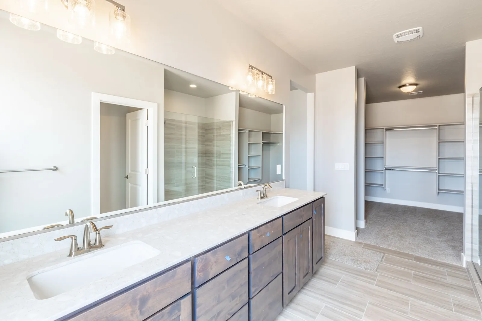 Double vanity with a walk-in closet beyond