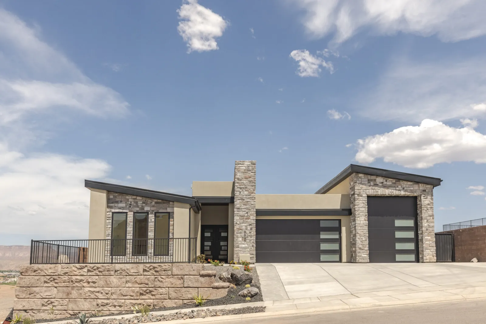 Modern home with a stone column on a hillside lot