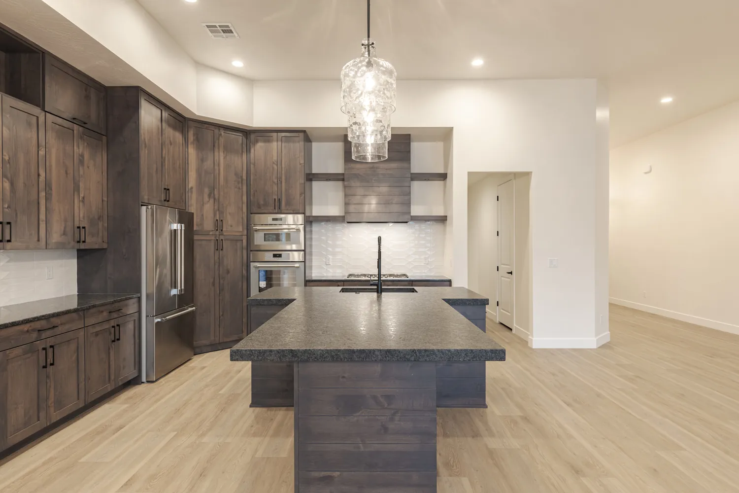 Kitchen with dark cabinets and a crystal pendant