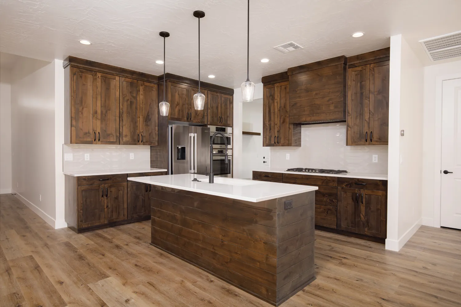 Kitchen with dark wood cabinets and pendant lights