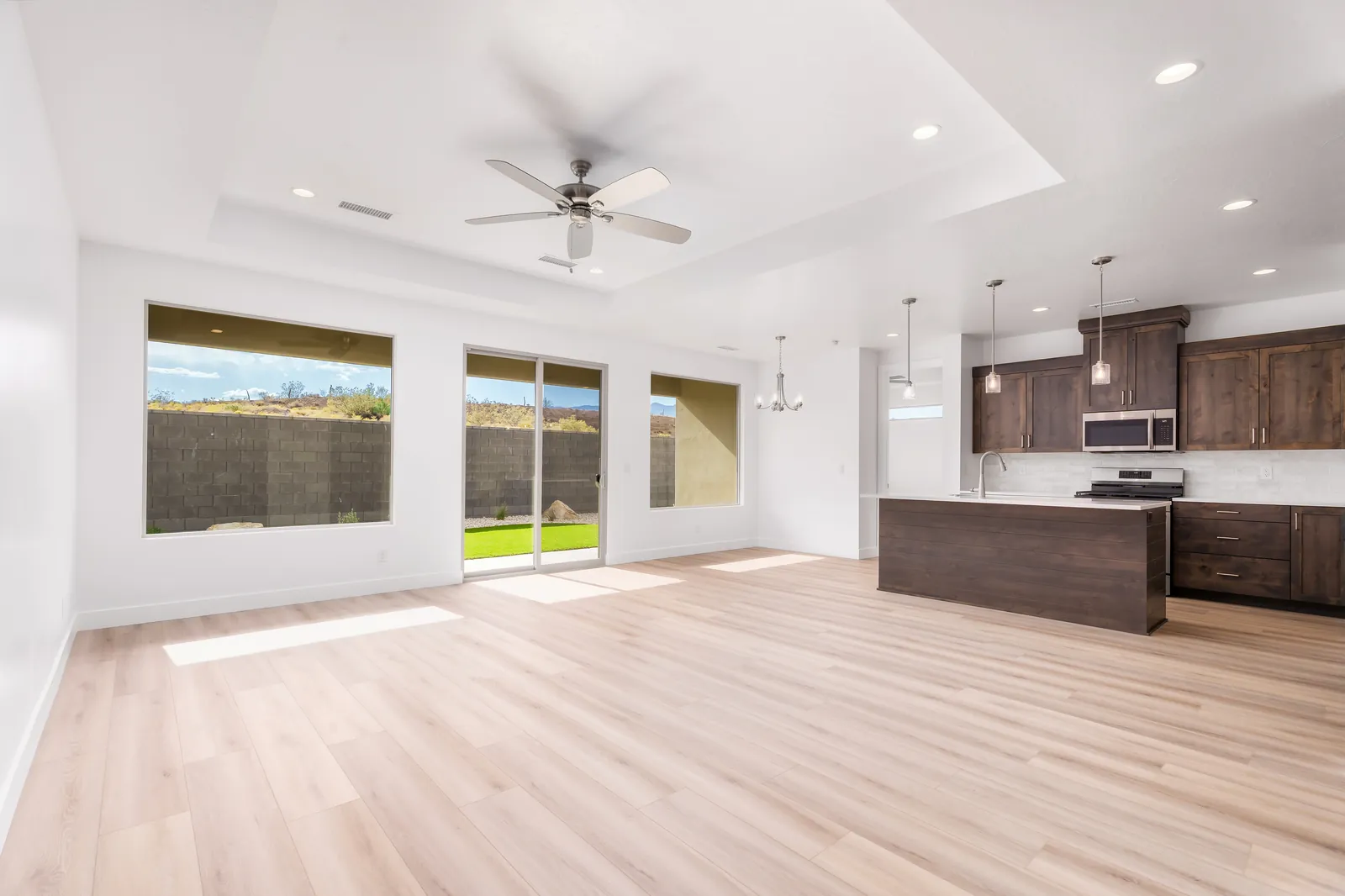 Great room with a ceiling fan, open to the kitchen