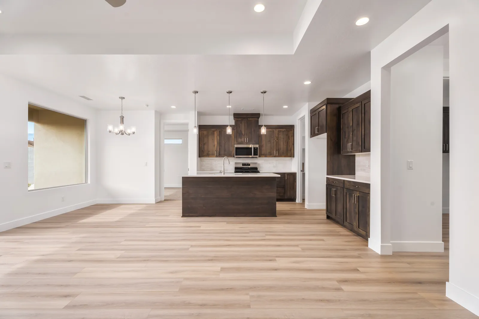 Kitchen with dark wood cabinets, an island and pendant lights