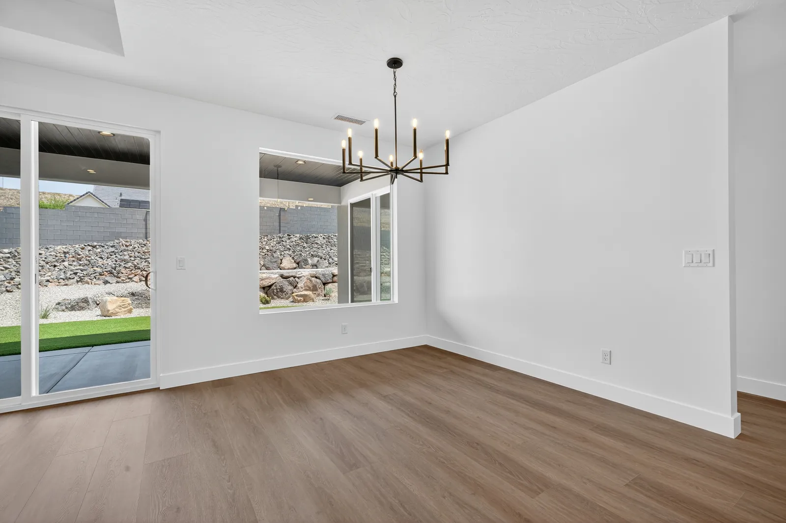 Dining area with a chandelier and windows onto the backyard