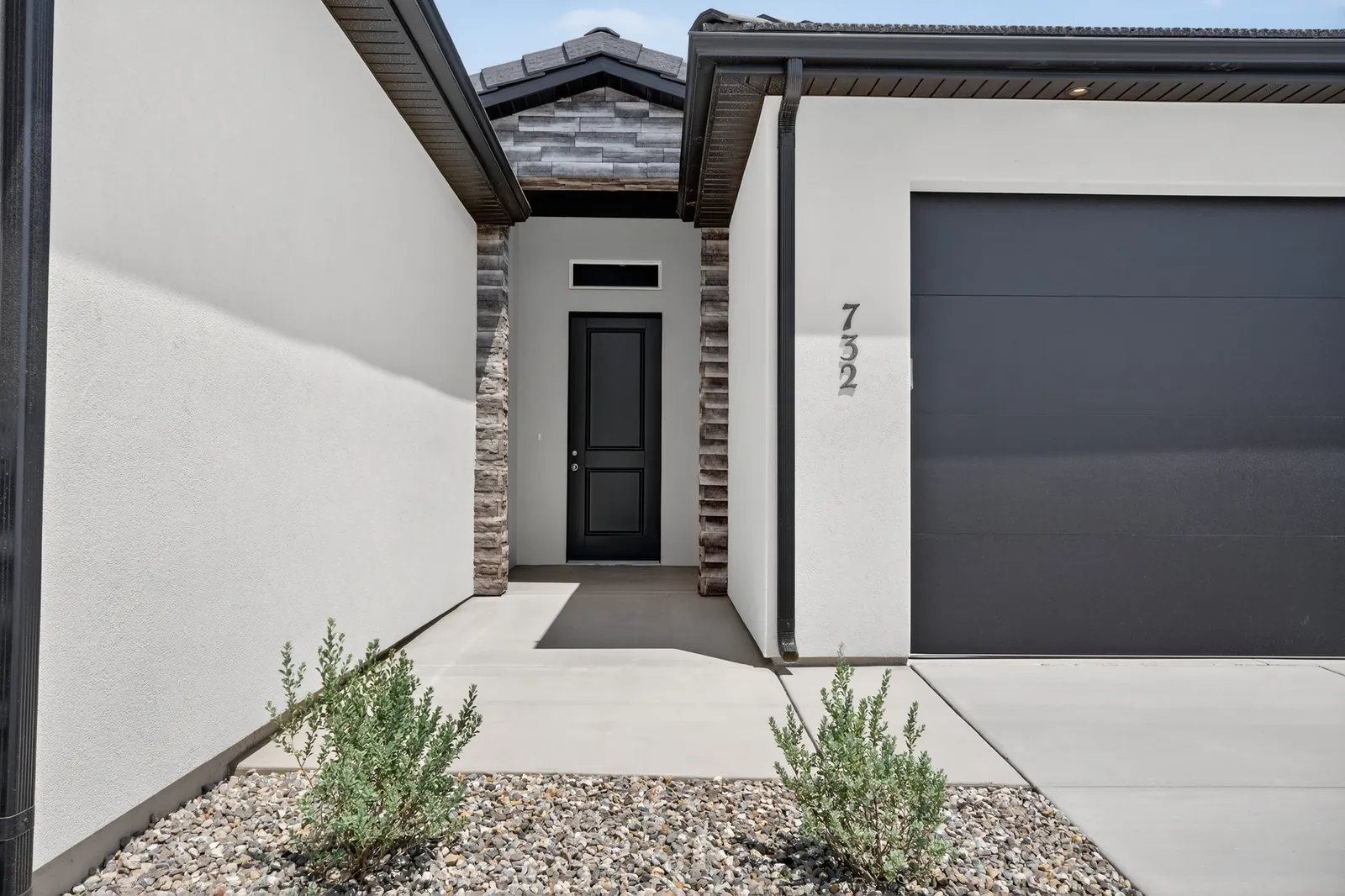 Front entry beside the garage, with a black door