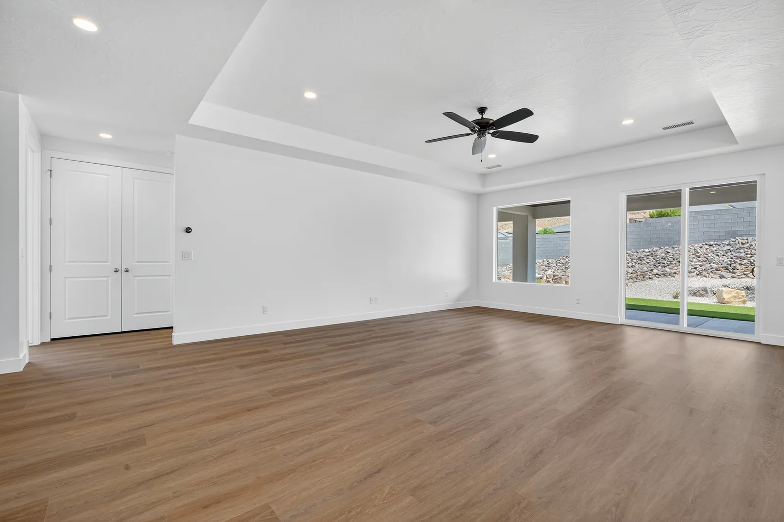 Great room with wood-look floors and windows to the yard