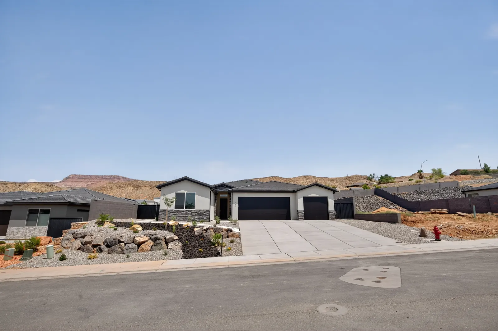 Two new homes on a La Verkin street with red cliffs behind