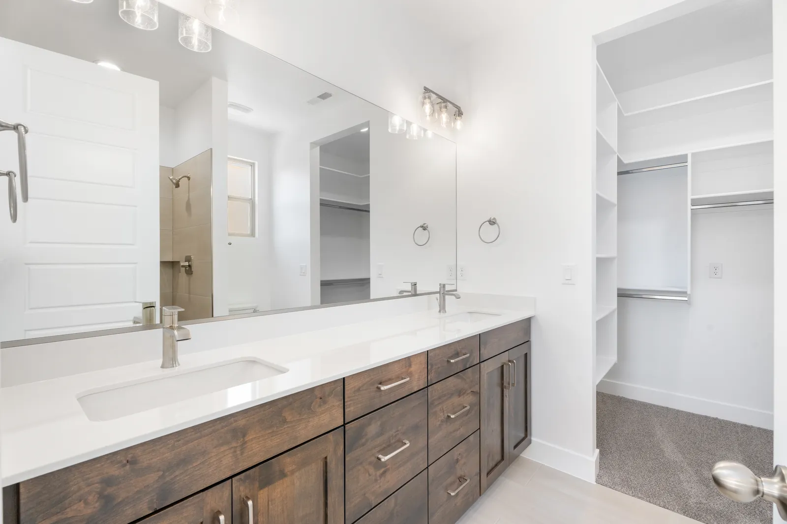 Double vanity with a walk-in closet beyond