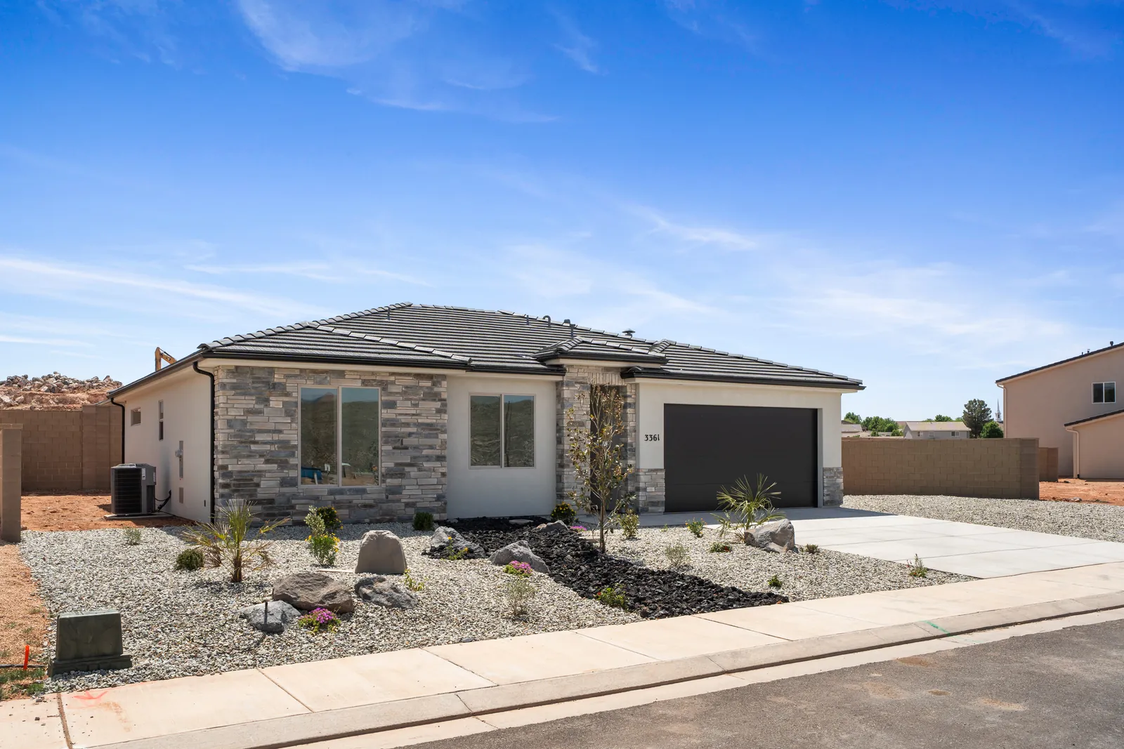 Front of a single-story home with a stone accent and desert landscaping