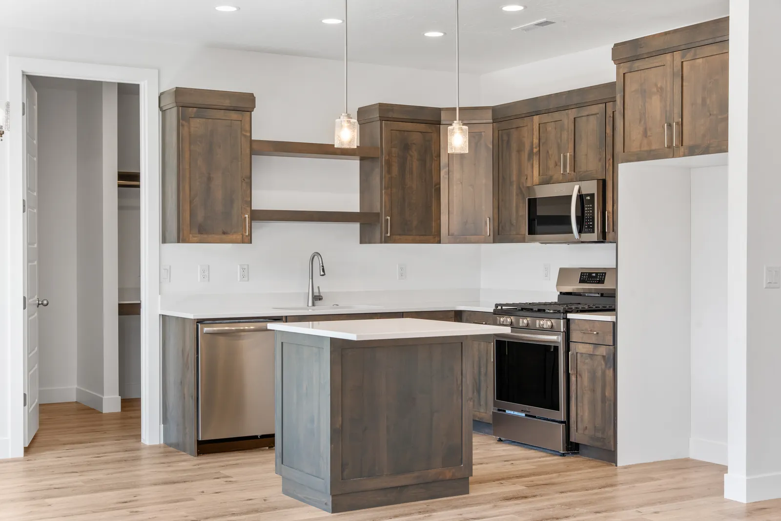 Kitchen with dark wood cabinets, an island and pendant lights