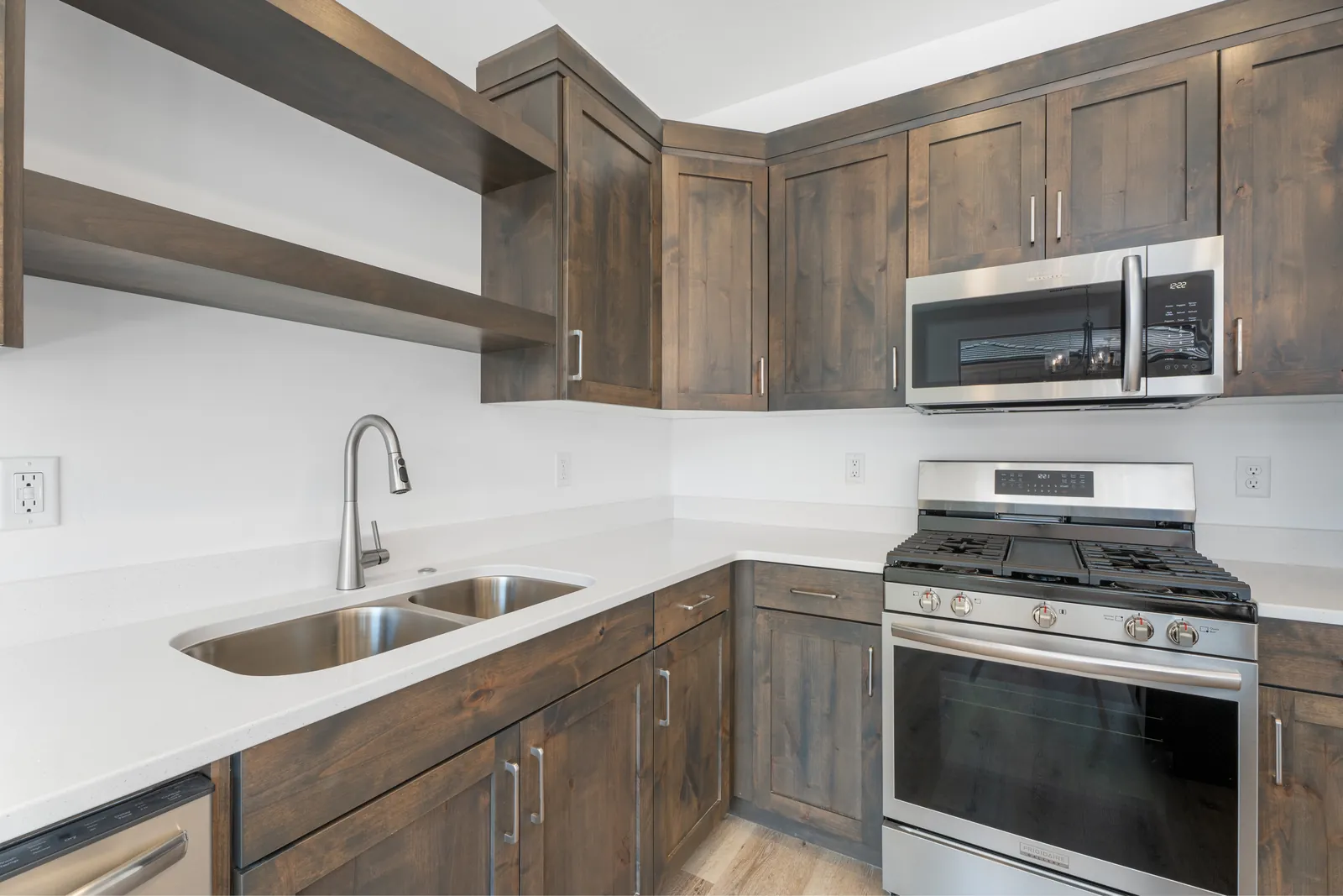 Gas range and microwave in dark wood cabinetry